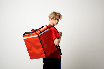 Delivery Service Cocnept. Courier wearing red uniform and thermo backpack bag looking at camera...