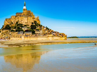 Le Mont Saint Michel, impressive view of the famous abbey during low tide on a bright sunny day,...