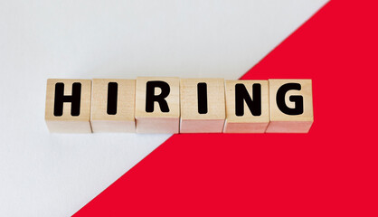 HIRE word made from building blocks on red and white background