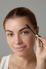 Eyebrow Care. Closeup Of Beautiful Woman Model With Eyebrow Brush .Young Female Face. Brow Care. Beauty cosmetics Concept.