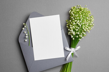 Wedding invitation card mockup with envelope and white lily of the valley flowers