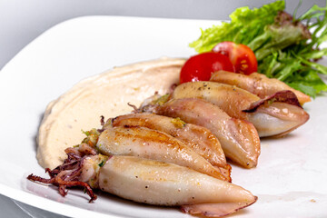 Mini squid stuffed with vegetables are on a plate