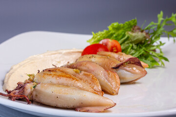 Mini squid stuffed with vegetables are on a plate