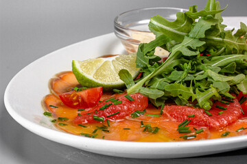 Salmon carpaccio with tomatoes, grapefruit and parsley