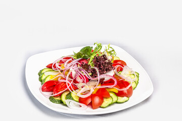 Vegetable salad of tomatoes, cucumbers, lettuce leaves, radishes, with olive oil