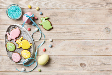 Colorful easter cookies in basket with Multi colors Easter eggs on colored background . Pastel color Easter eggs. holiday concept with copy space