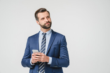 Pensive thoughtful caucasian young businessman ceo boss contemplating using smart phone cellphone for e-banking, e-learning, e-commerce isolated in white
