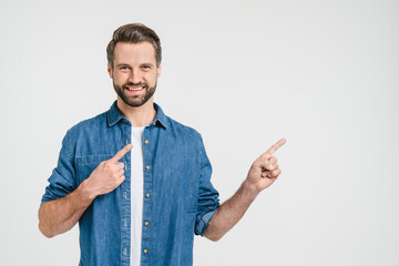 Happy smiling caucasian man freelancer student in denim clothes pointing showing at copy space...