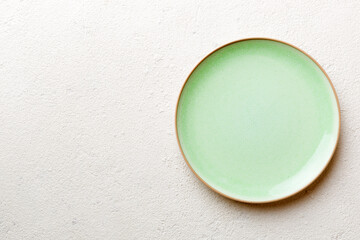 Top view of empty green plate on cement background. Empty space for your design