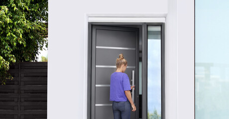 Fototapeta premium Beautiful woman opening the door of her home.