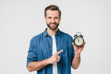 Smiling caucasian young man freelancer student holding alarm clock for deadline, being late, high...