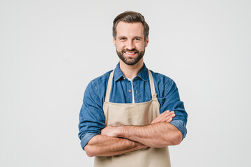 Confident smiling caucasian young man student bartender barista in apron with arms crossed looking...