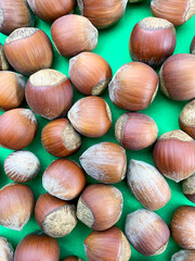 hazelnuts. nuts are scattered on a green background. top view.