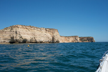 Fototapeta na wymiar Impressive cliffs on Algarve coast seen from a boat. Portugal