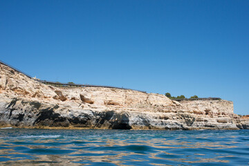 Fototapeta na wymiar View of coast of Algarve from a boat. Summer, calm water. Portugal
