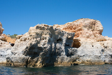 Fototapeta premium Close up of the rocky coast at Algarve, Portugal, seen from the ocean.