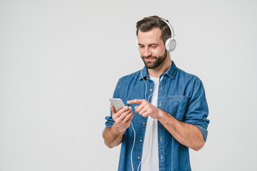 Caucasian young student man freelancer listening to the music in headphones, choosing sound track,...