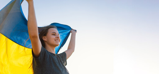 Woman holding a yellow and blue flag of Ukraine in outdoors. Independence Day. Flag Day....