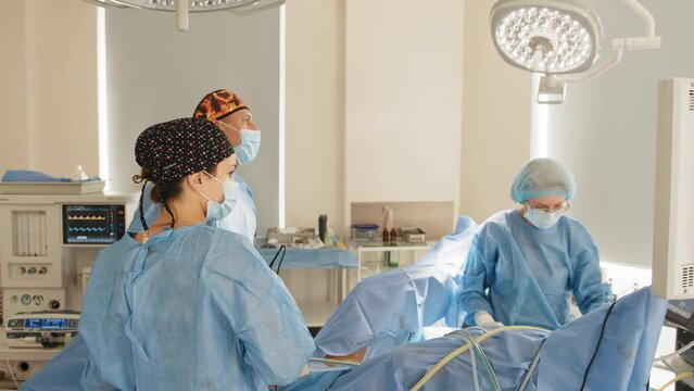 Male surgeon preforming operation uterus removal in hospital operating theater, man surgeon operating patient working with surgical laparoscopy instruments. Gynecology