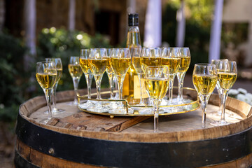 Wine glasses with white whine served on a wooden barrel outdoors