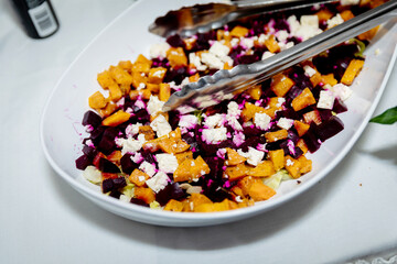 Vegetarian Roasted Pumpkin, Beetroot and Feta Salad in a white server on a white tablecloth