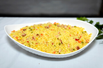 Aromatic yellow rice served in a square white server 