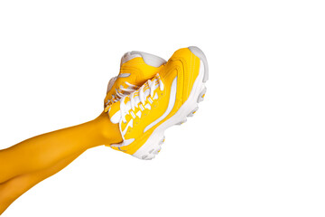 New Yellow female sneakers on long slender woman legs in yellow tights isolated on white background. Banner with copy space.