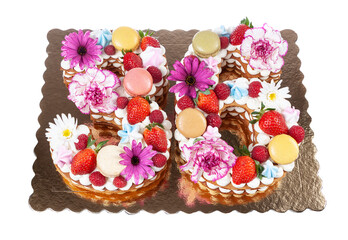 Fototapeta na wymiar Festive original cake in the form of numbers thirty-six covered with sweets and fruits with flowers. On a white isolated background.