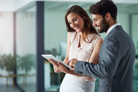 Positivity inspires productivity. Shot of a young businessman and businesswoman using a digital tablet together in an office.
