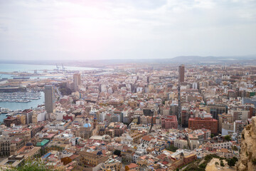Fototapeta na wymiar Wide angle view of the modern city of Alicante, Spain. Panoramic view of the city with houses, skyscrapers, churches and a harbor with yachts