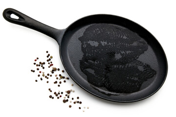 Wet imprint of raw fish fillets in a cast iron pan