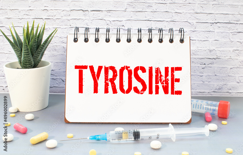 Poster notepad with the text and chemical structure of l tyrosine on table with pills stethoscope.