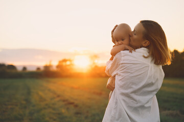 Loving mother and baby at sunset. Beautiful woman and small child in nature background. Concept of...