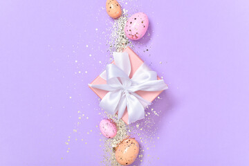 Easter composition with a gift and Easter eggs on a purple background