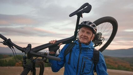 Active senior man biker carrying his bike outdoors in nature in autumn day. - Powered by Adobe