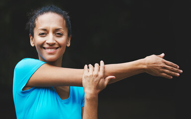My workout is not limited to opening hours. Shot of a woman loosening up before her workout.