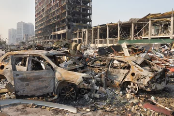 Fototapete Kiew Russia war damage building destruction city war ruins city damage car. Terror attack bomb shell of civilian bombed. Disaster area. 2022 Russian invasion of Ukraine war torn city destroyed car burn out