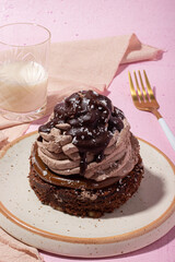 Brownie with buttercream and chocolate in pink background 