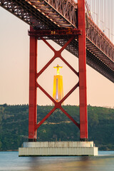 Cristo Rei or Christ the King statue seen across The 25 de Abril bridge over the Tajo River with in...