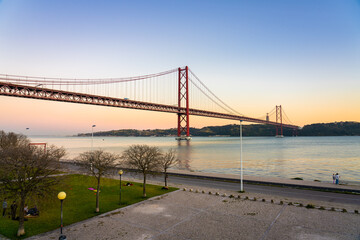 The 25 de Abril bridge over the Tajo River with Cristo Rei or Christ the King in the background. Lisbon. Portugal