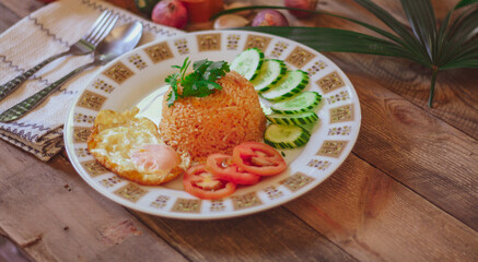 Fried Rice with Fried Egg Put on the wooden table and the tomatoes, cucumbers, garlic, shallots