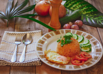 Fried Rice with Fried Egg Put on the wooden table and the tomatoes, cucumbers, garlic, shallots