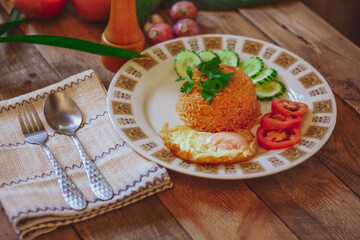 Fried Rice with Fried Egg Put on the wooden table and the tomatoes, cucumbers, garlic, shallots
