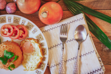 Fried Rice with Fried Egg Put on the wooden table and the tomatoes, cucumbers, garlic, shallots