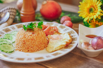 Fried Rice with Fried Egg Put on the wooden table and the tomatoes, cucumbers, garlic, shallots