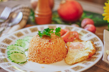 Fried Rice with Fried Egg Put on the wooden table and the tomatoes, cucumbers, garlic, shallots