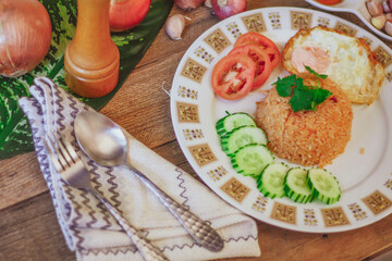 Fried Rice with Fried Egg Put on the wooden table and the tomatoes, cucumbers, garlic, shallots