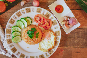 Fried Rice with Fried Egg Put on the wooden table and the tomatoes, cucumbers, garlic, shallots