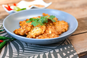 Corn Fritters With chili sauce placed on a wooden table