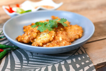 Corn Fritters With chili sauce placed on a wooden table